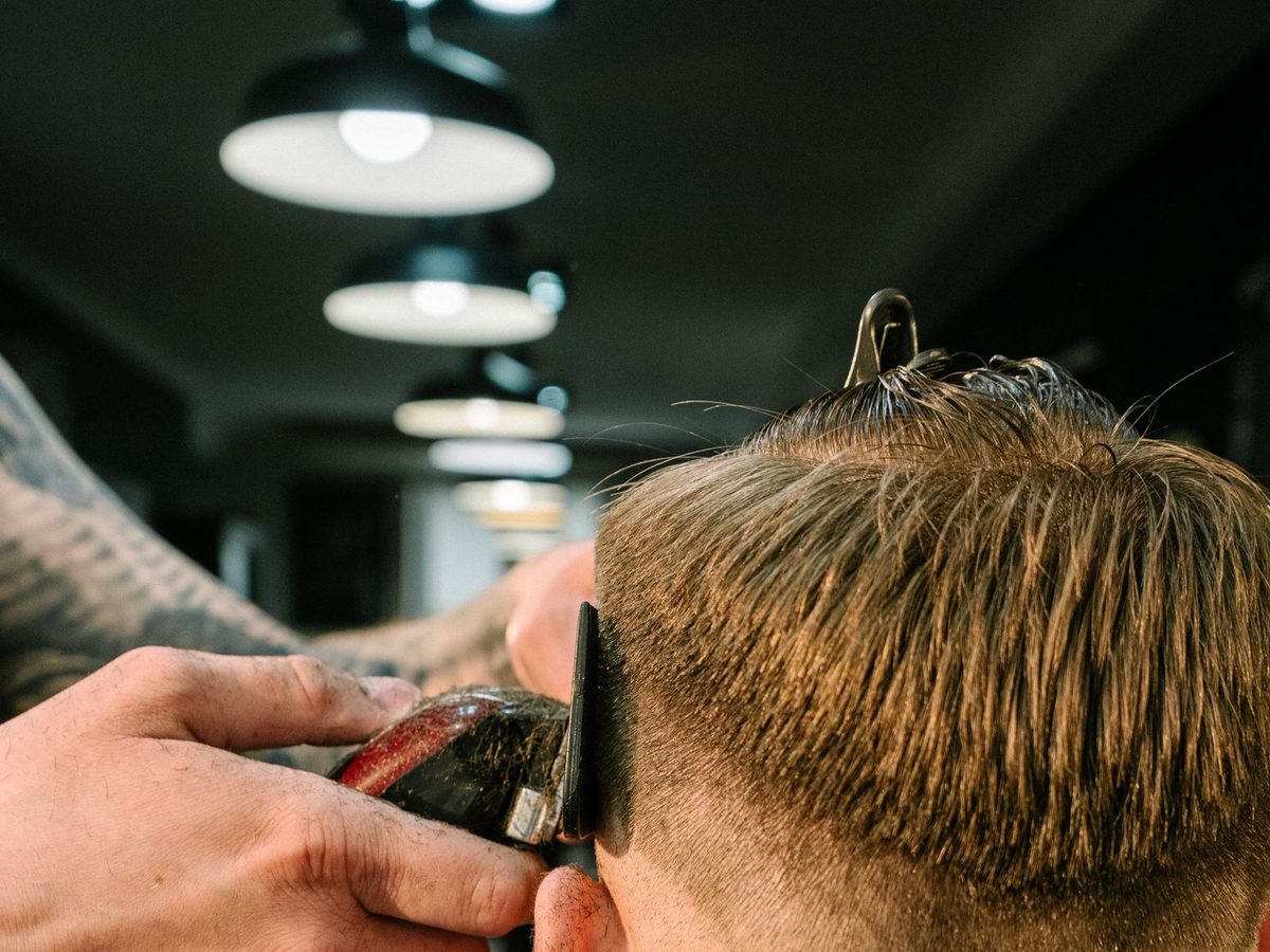A barber cutting a client's hair, one of the trades Dam AI serves