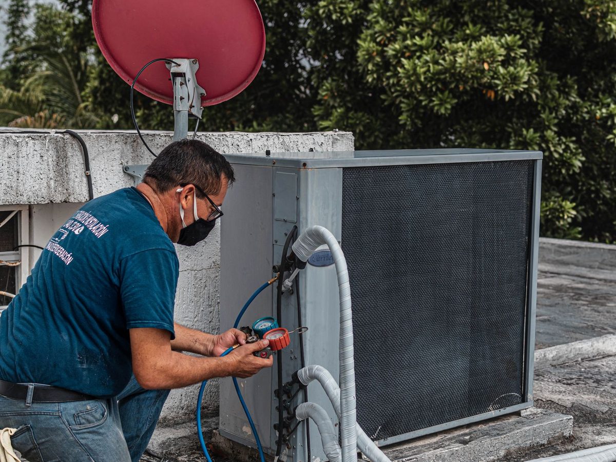 An HVAC technician servicing a unit, one of the trades Dam AI serves